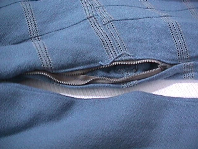 Close-up of a blue wool crepe dress with its side-seam metal zipper partly open